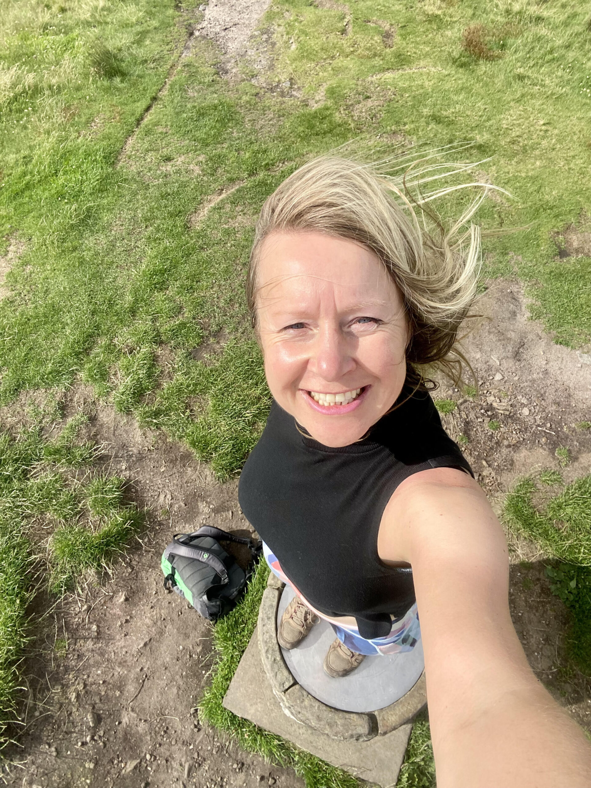 woman doing a selfie on a hill.