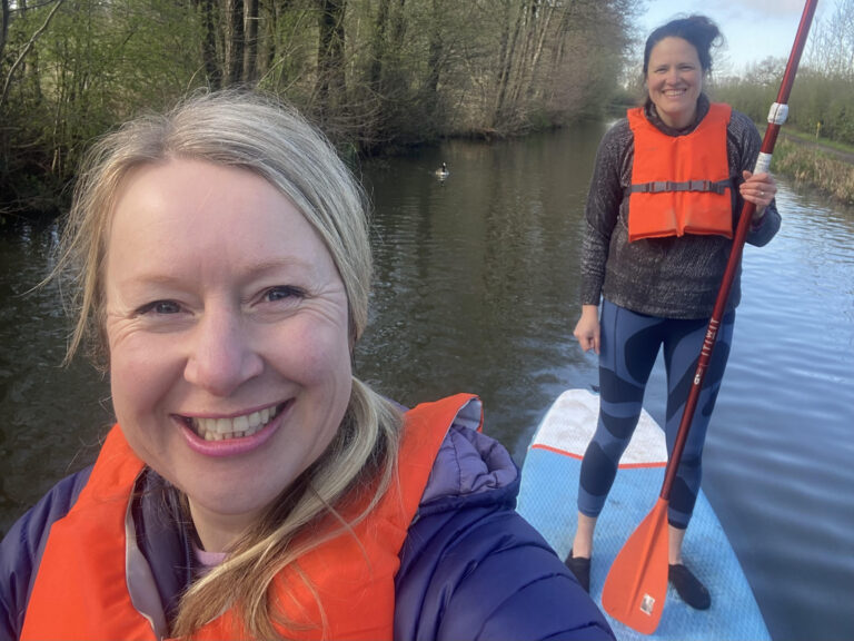 two women paddleboarding.